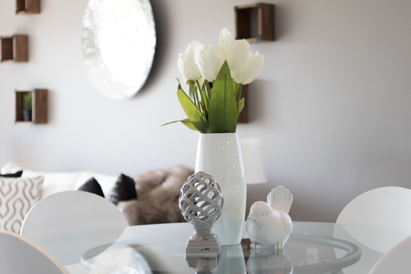 Home staging with a glass dining table, white tulips and decorative details
